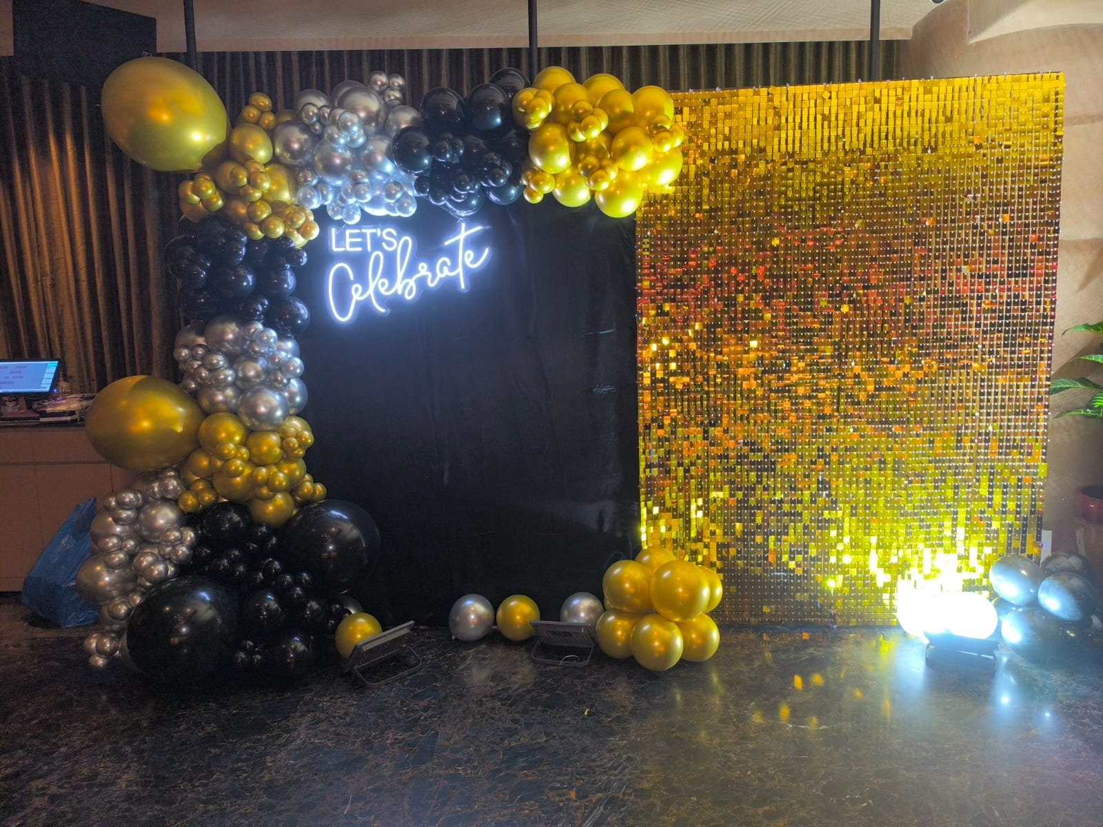 Let's Celebrate neon sign with gold and black balloon garland and shimmer sequin wall corporate event decoration by Star Balloon