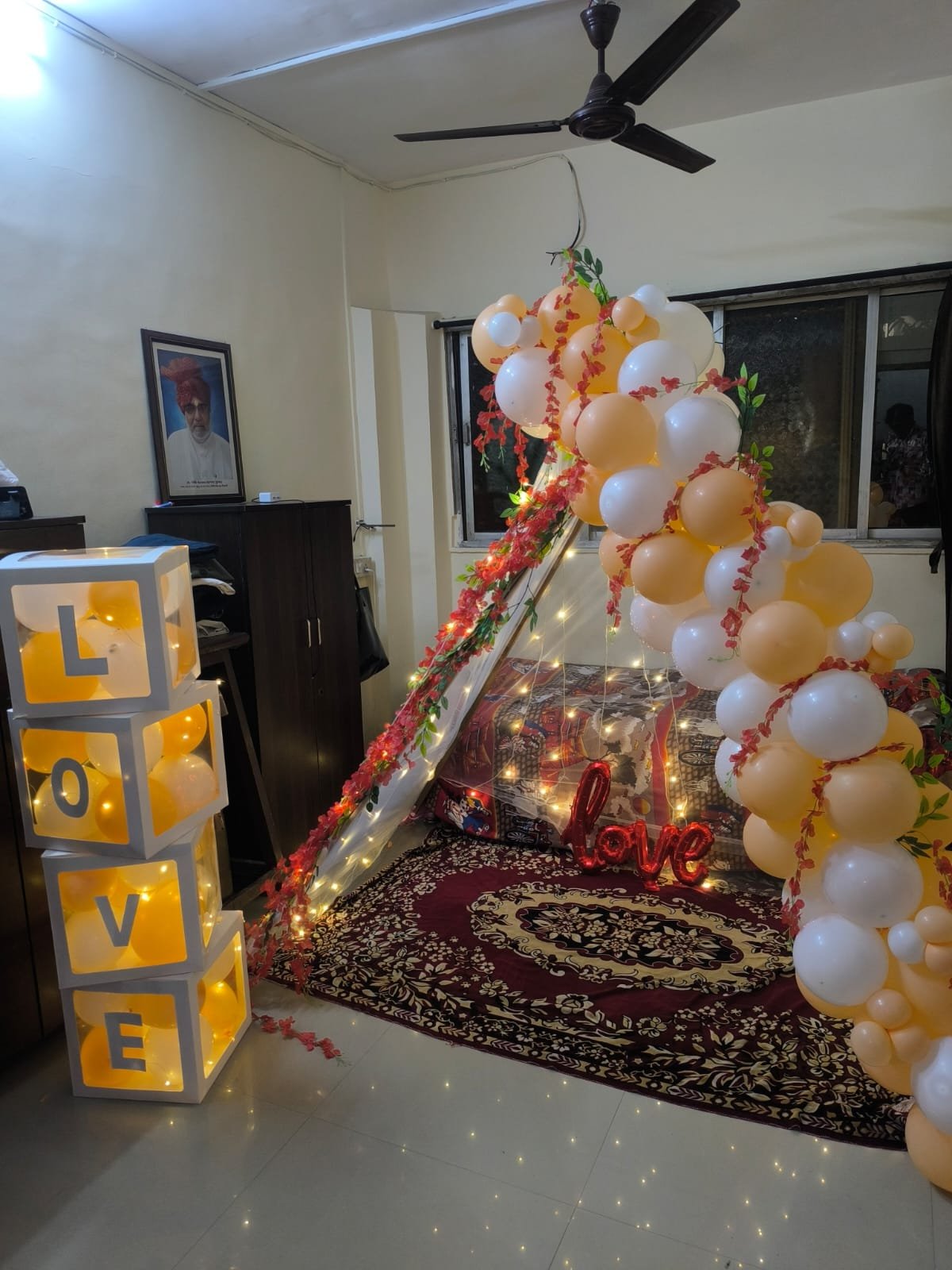 Romantic proposal decoration with LOVE blocks, white canopy, fairy lights and balloon garland by Star Balloon